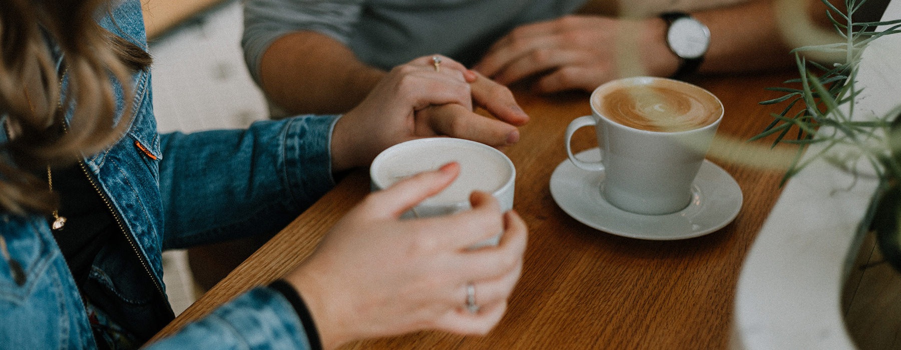 Couple drinking coffee and holding hands